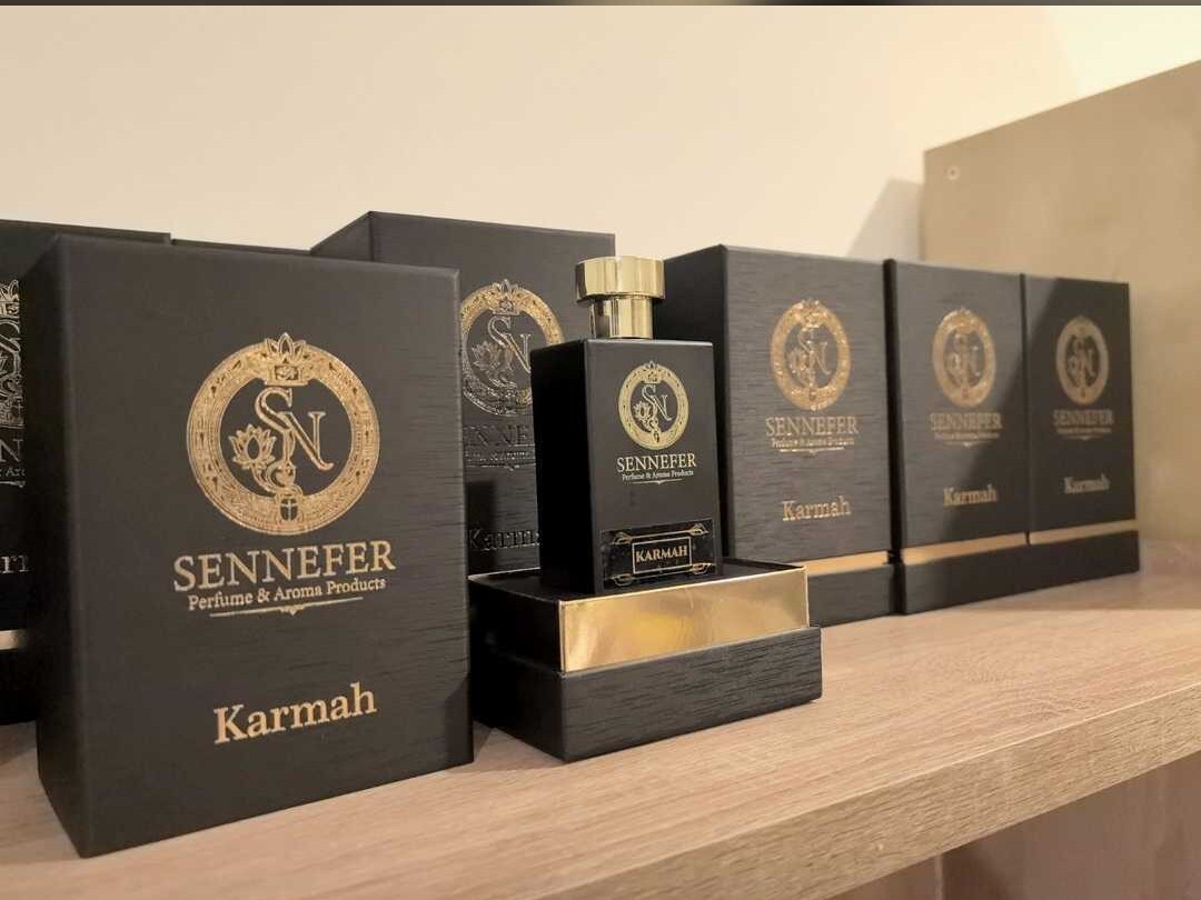 A SENNEFER Karmah bottle standing in its gold-lined box beside the branded packaging